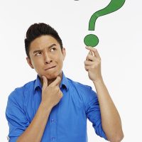Man holding up a question mark symbol, contemplating