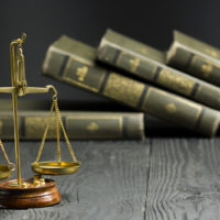 Law Concept - Open Law Book With A Wooden Judges Gavel On Table