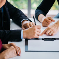 What should an adviser actually want: for BDBN to override pension docs, or vice versa? Close-up of married couple signing papers alongside with other witness or agent - can be divorce, law, liability, evidence agreement for marriage