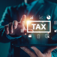 Division 296 CGT adjustment — How and when to opt-in e-tax, Businesman show TAX for Individual income tax return form online for tax payment concept. Government, state taxes. Data analysis, paperwork, financial research, report. Calculation tax return.