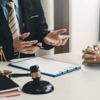Legal documents – non-legally qualified supplier v. law firm Image lawyer businessman sitting at the office with a woman customer explaining the agreement of advice.